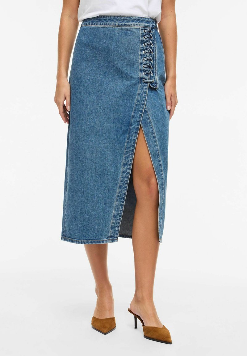 Denim-Midirock in Hellblau mit einem Frontschlitz und seitlichen Schnürdetails. Verfügt über einen rohen Saum und ein klassisches Fünf-Taschen-Design.