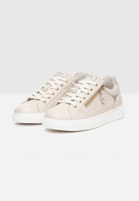 Beżowe skórzane sneakersy z białą gumową podeszwą. Do cech należy metalowy zamek, sznurowadła oraz teksturowany wzór na boku.