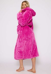 Fuchsia zachte badjas met capuchon, geribbeld textuur, ceintuur in de taille en geschulpte randdetail, tot halverwege de kuit. Zacht, dik materiaal.