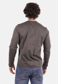 Koszula z długim rękawem w ciemnoszarym kolorze, z okrągłym dekoltem i gładką fakturą. Widok z tyłu pokazuje dopasowany krój i minimalną ilość szwów.