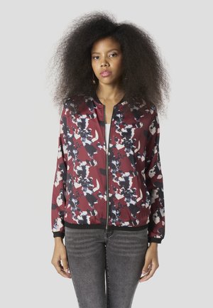 Bomberjack met een bordeauxrode bloemenprint, zwarte accenten en een ritssluiting aan de voorkant. Voorzien van geribde manchetten en tailleband, lichtgewicht stof.