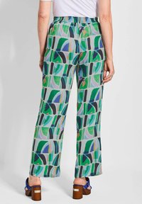 Vloeiende, wijde broekspijpen in een lichte stof, met een kleurrijk geometrisch patroon van groen, blauw en zwart en een elastische tailleband.