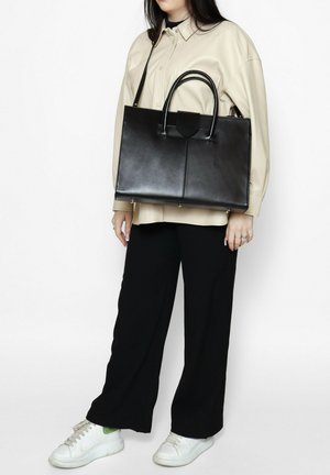 Borsa a tracolla nera in pelle con un design strutturato, due manici superiori, una chiusura a pattina e dettagli hardware minimalisti.