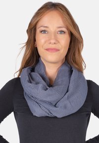 Écharpe infinie douce et texturée d'une couleur bleu-gris profond, enroulée autour du cou, avec un tissu drapé et superposé créant des plis doux.