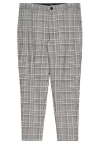 Šedé kostkované kalhoty s upraveným střihem, s kostkovaným vzorem v různých odstínech šedé a bílé. Hladká textilie, zapínání na zip.