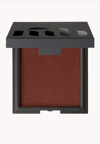 Brun rougepulver i en fyrkantig svart kompakta med en texturerad yta. Locket har utskurna bokstäver. Kompaktens dimensioner är små och portabla.