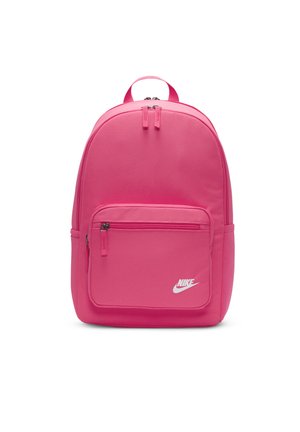 Różowy plecak wykonany z fakturowanej tkaniny, z dużą główną komorą, przednią kieszenią na zamek błyskawiczny oraz białym logo Nike z przodu.