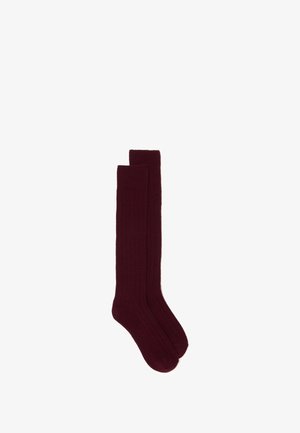 Chaussettes bordeaux montantes avec une texture côtelée, présentant un design uni et un tissu doux, adaptées pour un port décontracté ou formel.