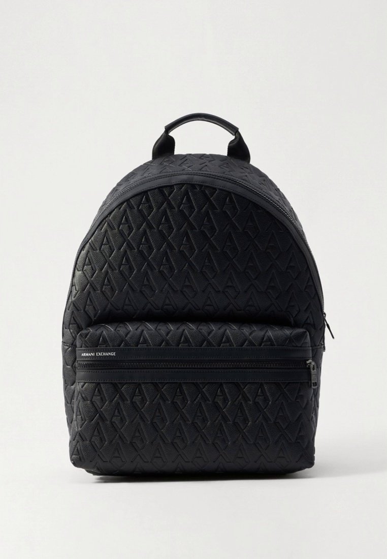Sac à dos noir avec matériau synthétique texturé, présentant un motif géométrique en relief, une poignée supérieure et une poche avant zippée.