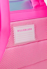 Rosa ryggsekk med meshstruktur og glatt stoff. Har et merke med "BILLIEBLUSH" trykt med fet rosa tekst og tomme linjer for personlig tilpasning.