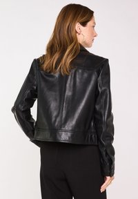 Veste en cuir noire au design court, à la texture lisse et aux détails de couture subtils. Comprend un col classique et des manches ajustées.