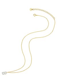 Zelta ķēdes kaklarota ar smalku dizainu. Iezīmējas ar mirdzošu, dimantiem izklātu burta 'B' piekariņu kā galveno elementu.