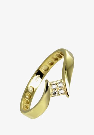 Bague en or avec un sertissage central orné de trois petites pierres précieuses, surface lisse et polie, et un design unique torsadé.