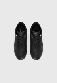 Black leather sneakers with round toes, tonal laces, and gold accents. Features a white rubber sole and a branded tongue.