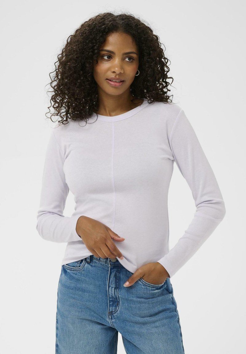 Lichtpaarse lange mouwen t-shirt, zachte stof, ronde halslijn, subtiele naaddetails, gedragen met lichtblauwe denim jeans.