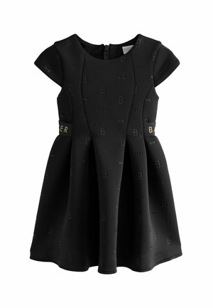 Schwarzes Kleid mit kurzen, schulterbedeckenden Ärmeln, strukturiertem Stoff mit einem subtilen "B"-Muster und einem goldenen Akzent in der Taille. Reißverschluss im Rücken.