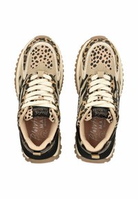 Pár béžových a černých tenisek s potiskem zvířecí srsti, bílými tkaničkami a robustními hnědými podešvemi, z pohledu shora na bílém pozadí.