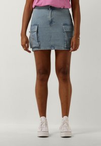 Lichtblauwe denim mini-jurk met twee voorklauwen, lichte slijtage aan de zoom en subtiele bloemborduursels op de zak.