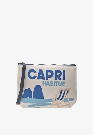 Borsetta in tela con cerniera blu navy, testo blu "CAPRI HABITUÉ,", formazioni rocciose blu e una sdraio a righe vicino all'acqua.
