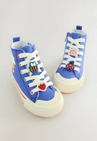 Blaue Canvas-Hochtop-Sneaker mit weißen Schnürsenkeln, die mehrfarbige Applikationen zeigen: Biene, Erdbeere, Regenbogen und Marienkäfer. Gummisohlen.