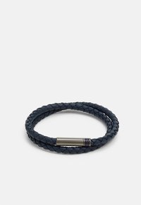 Il bracciale in pelle intrecciata di colore blu navy presenta una chiusura metallica elegante con scanalature sottili, che mette in mostra una texture dettagliata e una forma circolare.