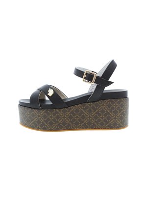 Zwarte plateau sandalen met gekruiste bandjes, een gesp en een gestructureerde, met patroon versierde sleehak met een gouden accentdetail.