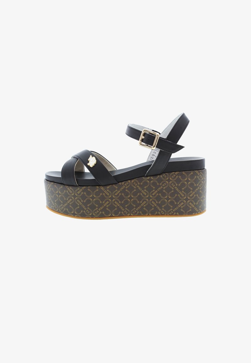 Sandales à plateforme noires avec brides croisées, une boucle, et une semelle compensée texturée et ornée d'un motif avec un détail accent doré.
