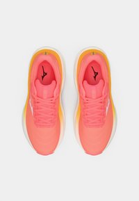 Tênis atléticos em rosa e laranja apresentam um cabedal texturizado, bico arredondado, cadarços planos e um logotipo branco na lateral, com uma sola espessa e acolchoada.