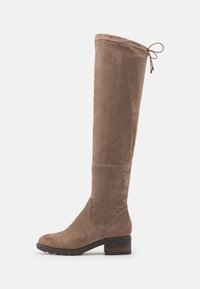Bota de ante marrón hasta la rodilla con punta redonda, tacón bajo en bloque y costuras decorativas en el eje. Cierre ajustable en la parte superior.