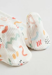Gerippte weiße Socken mit bunten abstrakten Mustern in Orange, Pink, Blau und Grün, mit runden und wellenförmigen Designs.