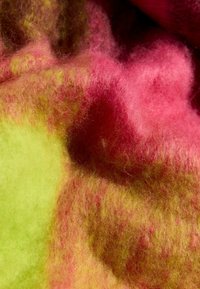 Felt vibrant care are un amestec de nuante de verde si roz, cu o textura moale si pufoasa si tranziții de culoare subtile.