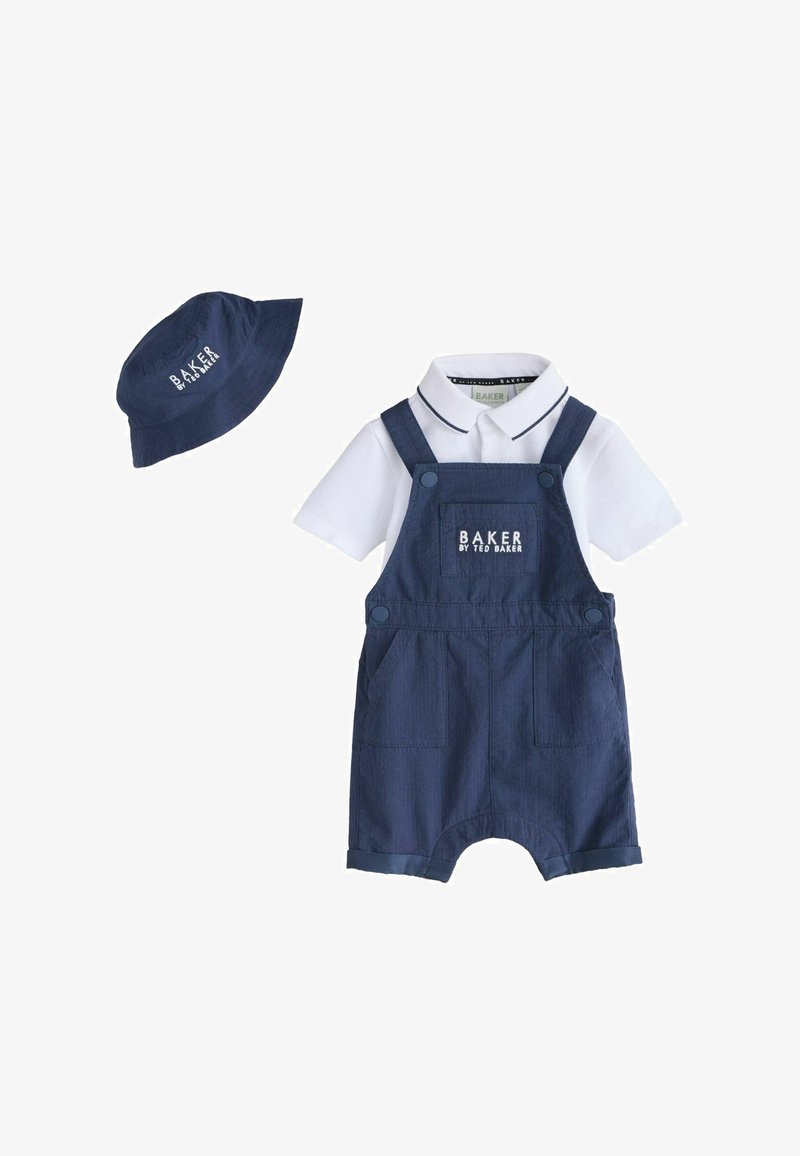 Combinaison bleu marine pour bébé avec poche avant et chemise blanche à col en dessous, assortie à un chapeau seau bleu marine.