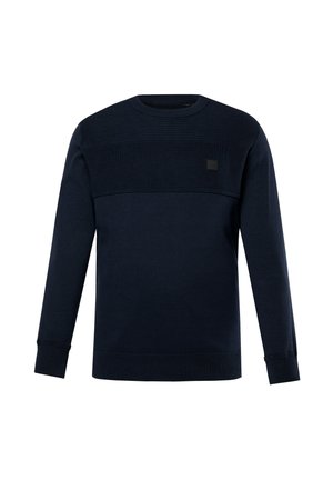 Granatowa bluza z teksturowanym górnym panelem, okrągłym dekoltem, długimi rękawami oraz prążkowanymi mankietami i dołem. Na przodzie znajduje się mała naszywka z logo.