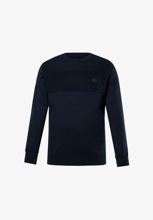 Granatowa bluza z teksturowanym górnym panelem, okrągłym dekoltem, długimi rękawami oraz prążkowanymi mankietami i dołem. Na przodzie znajduje się mała naszywka z logo.