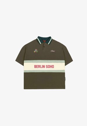 Olivinės spalvos polo marškiniai su trumpomis rankovėmis, dryžuota apykaklė žalia ir šviesiai mėlyna, su balta juosta, ant kurios raudonai parašyta "BERLIN SOHO".