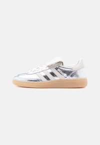 Baskets Adidas Spezial métalliques argentées avec des rayures blanches et une semelle en gomme, vues de profil gauche sur un fond blanc uni.