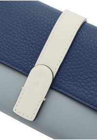 Modrý texturovaný kožený peněženka s světle šedou spodní částí, vybavený bílým popruhem a kovovým akcentem se subtílním logem.