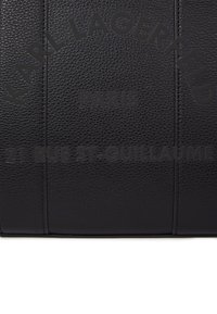 Μαύρο υφή δέρμα με ανάγλυφο κείμενο "KARL LAGERFELD PARIS 21 RUE ST-GUILLAUME" σε ημικύκλιο και ευθείες γραμμές.