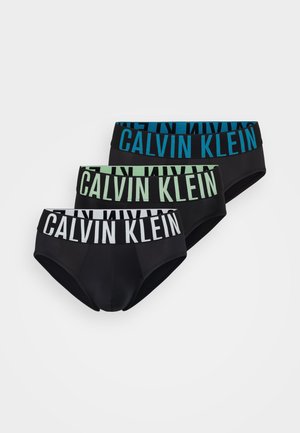 Drie paar zwarte onderbroeken met contrasterende elastische taillebanden in blauw, groen en wit. Elk heeft het "CALVIN KLEIN"-logo prominent aanwezig.