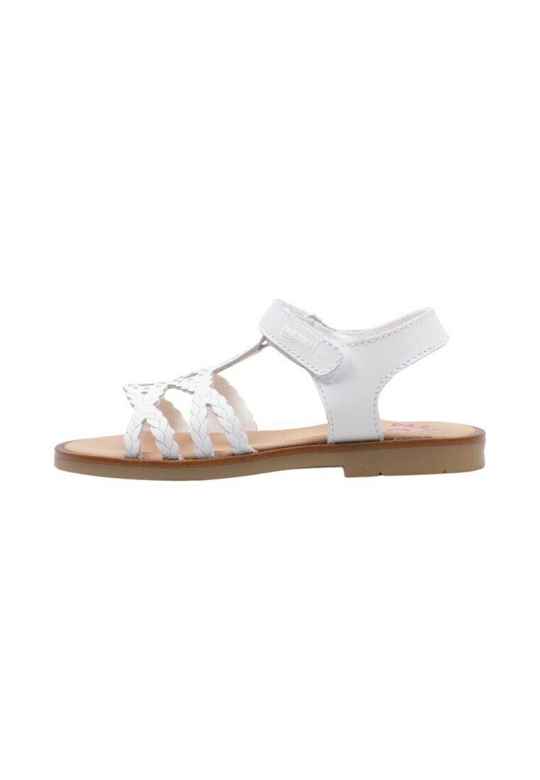 Sandalias blancas con tiras trenzadas, una correa en el tobillo trasero y una suela plana. El interior tiene un color marrón claro. Adecuadas para uso casual.