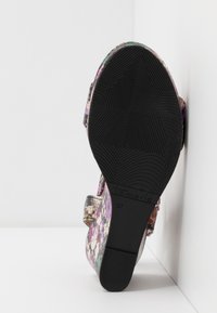 Sandale à motif floral avec une semelle en caoutchouc noir texturée, dotée d'un talon bas et d'une bride réglable. Taille indiquée : 37.