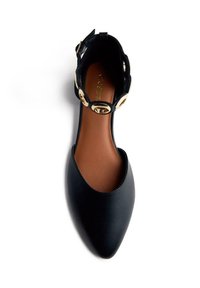 Ballerines noires en cuir avec un bout pointu, dotées d'une fine sangle à la cheville et d'accents en métal doré en forme de cercle. Texture lisse et semelle intérieure marron.