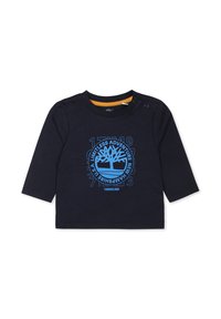 Marineblauw langemouwshirt met blauw boomborduur en tekst. Voorzien van schouderknopen voor gemakkelijk aan- en uittrekken. Zachte katoenstof, eenvoudige ronde hals.