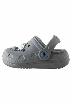 Sabot gris à enfiler avec doublure duveteuse, bride de talon réglable, trous de ventilation et petites décorations en forme d'animaux sur le dessus.