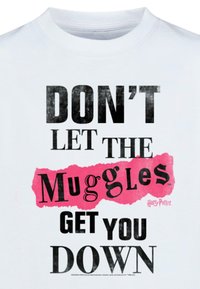 Balta marškinėliai su juodu ir rožiniu grafiniu tekstu: "NELEISK, KAD MUGGLIAI TAVE NUSIVERTINTŲ." Įtrauktas "Harry Potter" logotipas.
