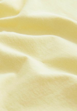Pamut anyag, finom pasztell sárga színben, sima textúrával, enyhe redőkkel és gyűrődésekkel.