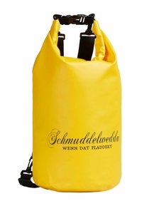 Žlutá voděodolná suchá taška s nastavitelnými černými popruhy. Obsahuje uzávěr na rolovací systém a potištěné logo "Schmuddelwedda" v černé barvě.