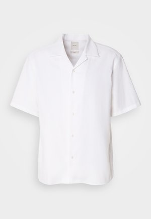 Chemise à manches courtes, boutons en lin blanc, dotée d'un col classique, d'une texture lisse et d'une coupe décontractée.