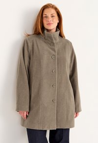 Khaki wollen jas met een hoge kraag, voorzien van vijf grote knopen en lange mouwen. Soepele textuur en een relaxte pasvorm.
