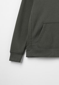 Tumma vihreä huppari, jossa on etutasku, resorit hihansuissa ja pehmeä tekstuuroitu kangas. Helma on ommeltu kestävyyden lisäämiseksi.